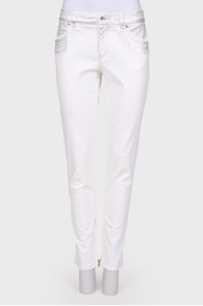 White jeans with a silver coating, with a tag