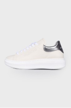 Sneakers in milky color with a tag