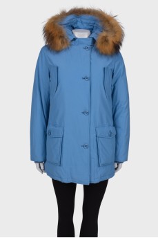 Blue parka with fur on the hood with a tag