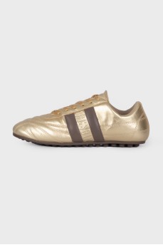 Gold sneakers with brand logo