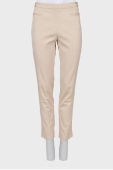 Beige trousers decorated with pockets