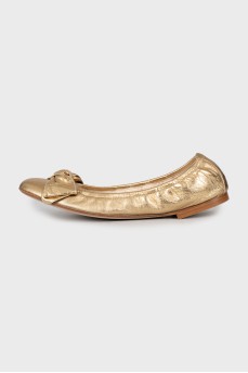 Golden ballet shoes decorated with a bow