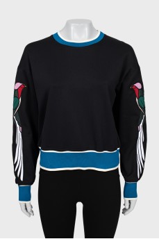 Cropped sweatshirt with patches on the sleeves