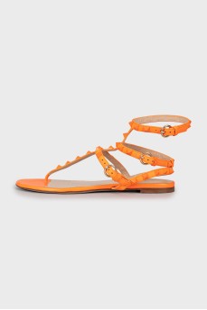 Orange sandals decorated with spikes