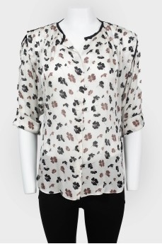 Blouse with a sleeve adjustable in length with a tag