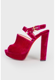 Purple suede high-heeled shoes with a tag