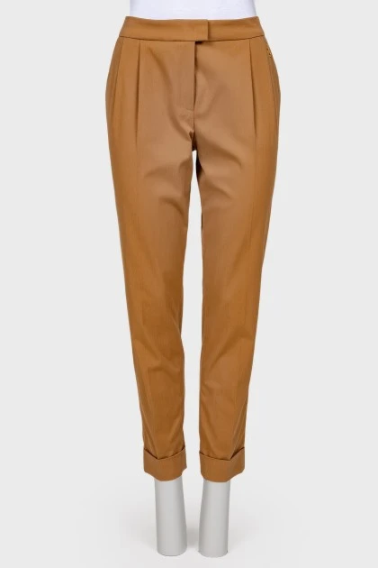 Classic trousers with creases and metal brooch