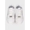 White sneakers with metallic brand logo