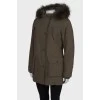 Green parka with fur on the hood with a tag