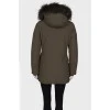 Green parka with fur on the hood with a tag