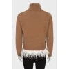 Sweater decorated with feathers at the bottom