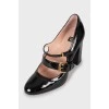 Lacquered shoes with golden buckle