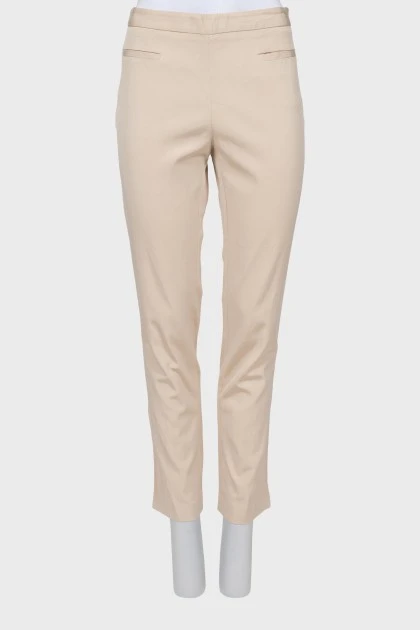 Beige trousers decorated with pockets