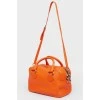 Bright orange leather bag with a zipper
