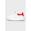 White leather sneakers with a red heel