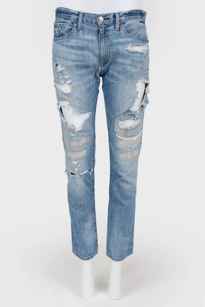 Blue jeans with scuffs and decorative slots